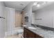 Well-lit bathroom with a granite countertop vanity, shower and tub combination at 1614 Rucker Rd, Alpharetta, GA 30009