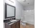 Modern bathroom featuring dark vanity with granite top, a large mirror, and a shower-tub combo at 1614 Rucker Rd, Alpharetta, GA 30009