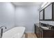 Luxurious bathroom with a soaking tub and a double sink vanity with granite countertops at 1614 Rucker Rd, Alpharetta, GA 30009