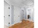 Hallway leading to bathroom showing hard wood floors, neutral paint, and white doors at 1614 Rucker Rd, Alpharetta, GA 30009