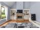 Bright living room with a stone fireplace, built-in bookcases, hardwood floors and an abundance of natural light at 1614 Rucker Rd, Alpharetta, GA 30009