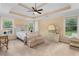 Spacious bedroom featuring tray ceiling with fan, large windows and elegant, neutral furniture at 1614 Rucker Rd, Alpharetta, GA 30009