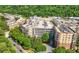 A high-angle view of a large complex with a parking garage, surrounded by mature trees and greenery at 200 River Vista Dr # 120, Atlanta, GA 30339