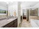 Modern bathroom featuring a granite countertop, soaking tub, and tiled shower with glass door at 200 River Vista Dr # 120, Atlanta, GA 30339