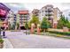 A multi-story condo building featuring balconies, mature trees and manicured landscaping at the entrance at 200 River Vista Dr # 120, Atlanta, GA 30339