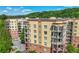 Beautiful condo building with balconies and a nearby parking lot surrounded by trees at 200 River Vista Dr # 120, Atlanta, GA 30339