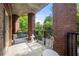 Covered patio with red brick pillars, lounge seating, and a view of mature trees at 200 River Vista Dr # 120, Atlanta, GA 30339