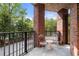 Relaxing covered patio featuring brick pillars, black railings, and a cozy seating area with chairs and a table at 200 River Vista Dr # 120, Atlanta, GA 30339