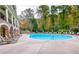 A luxurious outdoor pool with lounge chairs surrounded by mature trees and landscaping at 200 River Vista Dr # 120, Atlanta, GA 30339