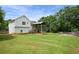 Spacious backyard with lush green grass, a wooden fence, and a covered deck with stairs at 259 Pine Valley Dr, Powder Springs, GA 30127