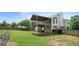 Backyard featuring a large green lawn, privacy fence, a covered deck, and mature trees at 259 Pine Valley Dr, Powder Springs, GA 30127