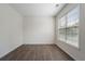 This empty bedroom has hardwood floors, a neutral paint color, and a large window for natural light at 4321 Sugar Maple Chase Nw, Acworth, GA 30101