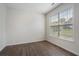 This empty bedroom has hardwood floors, a neutral paint color, and a large window for natural light at 4321 Sugar Maple Chase Nw, Acworth, GA 30101