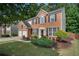Traditional two-story brick house featuring a landscaped yard, driveway, and mature trees at 4321 Sugar Maple Chase Nw, Acworth, GA 30101