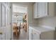 Hallway with white cabinets leading into a dining room with a wooden table and natural light at 4321 Sugar Maple Chase Nw, Acworth, GA 30101
