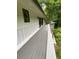 Long, gray deck off back of house, with small black windows and a view of wooded area at 4717 Westhampton Dr, Tucker, GA 30084