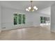 Open living room design with an elegant chandelier and large windows offering views of the trees at 4717 Westhampton Dr, Tucker, GA 30084