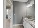 Bathroom featuring double sinks with granite countertops, modern lighting fixtures and gray walls at 629 Windsor Sw St, Atlanta, GA 30312
