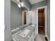 Bathroom featuring double sinks with granite countertops, modern lighting, and access to the closet at 629 Windsor Sw St, Atlanta, GA 30312