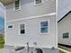 Side view of a home with light gray siding, double-hung windows, and gray brick foundation at 629 Windsor Sw St, Atlanta, GA 30312