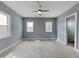 Spacious primary bedroom with two windows, neutral carpet, and a ceiling fan at 629 Windsor Sw St, Atlanta, GA 30312
