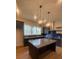 Well-lit kitchen featuring a large island, stainless steel appliances, and sleek dark cabinetry at 115 Pinecone Pkwy, Alpharetta, GA 30022