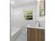 Cozy bathroom features a tub, tiled walls, a bright window, and a modern sink vanity at 174 Zelma Sw St, Marietta, GA 30060