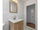 Bathroom with modern vanity and wood-look cabinet, tiled walls, and doorway at 174 Zelma Sw St, Marietta, GA 30060