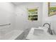 Cozy bathroom features a tub, tiled walls, a bright window, and a modern sink vanity at 174 Zelma Sw St, Marietta, GA 30060