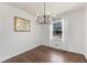 Elegant dining room featuring modern chandelier, large window with sheer curtains, and beautiful hardwood floors for stylish dining at 174 Zelma Sw St, Marietta, GA 30060