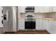 Close up of stainless steel kitchen appliances with white cabinets and wood counters at 174 Zelma Sw St, Marietta, GA 30060