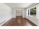 Sunlit living room features beautiful hardwood floors, fresh white walls, and a large window with charming sheer curtains at 174 Zelma Sw St, Marietta, GA 30060