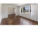 Sunlit living room features beautiful hardwood floors, fresh white walls, and a large window with charming sheer curtains at 174 Zelma Sw St, Marietta, GA 30060