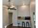 Open living space featuring a bar area, hardwood floors, a ceiling fan, and neutral wall paint at 386 Teal Ct, Roswell, GA 30076