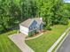 Aerial view of a two-story home with an attached garage, surrounded by lush greenery and a long driveway at 4638 Arrow Wind Dr, Powder Springs, GA 30127
