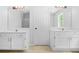 Bathroom featuring dual vanities with mirrors and white cabinetry at 4638 Arrow Wind Dr, Powder Springs, GA 30127