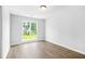 A bright empty bedroom with double windows showing lawn outside and hardwood floors at 4638 Arrow Wind Dr, Powder Springs, GA 30127
