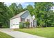 Charming two-story home with a well-manicured lawn, stone accents, red shutters, a bright red front door, and a side garage at 4638 Arrow Wind Dr, Powder Springs, GA 30127