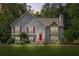 Charming two-story home with a well-manicured lawn, stone accents, red shutters and a bright red front door at dusk at 4638 Arrow Wind Dr, Powder Springs, GA 30127