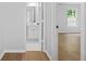 Bright hallway leads to the updated bathroom with white cabinets and tile flooring and light hardwood flooring throughout at 4638 Arrow Wind Dr, Powder Springs, GA 30127