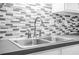 Close-up of a kitchen sink with stainless steel faucet and stylish backsplash at 4638 Arrow Wind Dr, Powder Springs, GA 30127