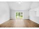 Bright, airy living room featuring hardwood floors, a large window, and vaulted ceilings at 4638 Arrow Wind Dr, Powder Springs, GA 30127