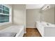 Well-lit bathroom featuring a soaking tub, double vanity and window with natural light at 771 Franklin Mill Trce, Loganville, GA 30052