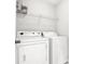 Functional laundry room with washer, dryer, and wire shelving at 771 Franklin Mill Trce, Loganville, GA 30052