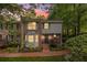 Brick home featuring meticulous landscaping, lush trees and a charming walkway at dusk at 1505 September Chase, Decatur, GA 30033
