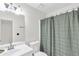 Bathroom features a white vanity, sink, toilet and a shower with a green curtain at 3327 James Harbor Way, Lawrenceville, GA 30044