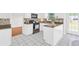 Bright eat-in kitchen boasts white cabinets, black appliances, and a backyard view at 3327 James Harbor Way, Lawrenceville, GA 30044