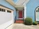 Close-up of a home's brick-lined entrance leading to a red front door with a white garage door to its side at 3740 Ashford Ne Pt, Brookhaven, GA 30319
