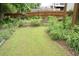 Landscaped backyard with garden beds surrounded by lush greenery and a wooden fence at 4020 Alligator Pt, Cumming, GA 30028