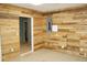 Spacious basement featuring wood walls and doorway to unfinished space at 4020 Alligator Pt, Cumming, GA 30028